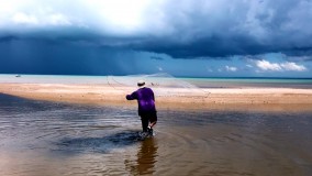 Storm clouds on the horizon while throwing the cast net